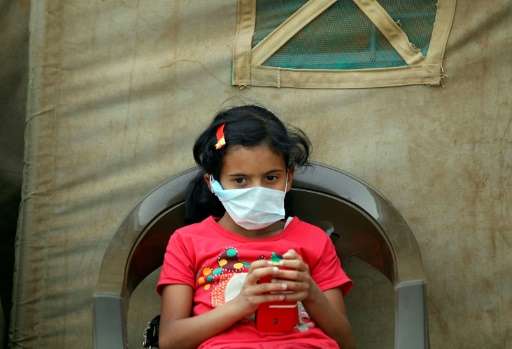 A Yemeni child suspected of being infected with cholera sits outside a makeshift hospital in Sanaa