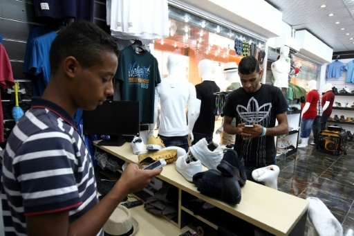 A young Libyan uses a mobile phone app to pay at a Benghazi store that accepts electronic payment systems