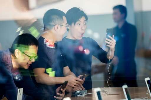 Chinese customers look at the new iPhone X at the Apple store in Hangzhou in China's eastern Zhejiang province, as the flagship 
