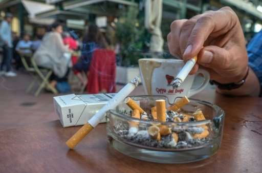 Clients of a coffee shop enjoy cigarettes with their drinks at  Vienna's most famous market, the Naschmarkt