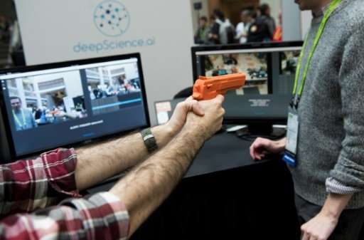Elliot Hirsch of Deep Science holds a fake gun as he demonstrates the company's security system to automatically detect firearms
