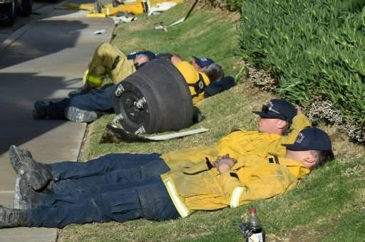 Exhausted firefighters have their first rest in over 20 hours since starting to fight the Lilac Fire in Bonsall, California