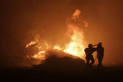 Firemen seek to control a blaze at Pietracorbara on August 11, 2017, on the French island of Corsica