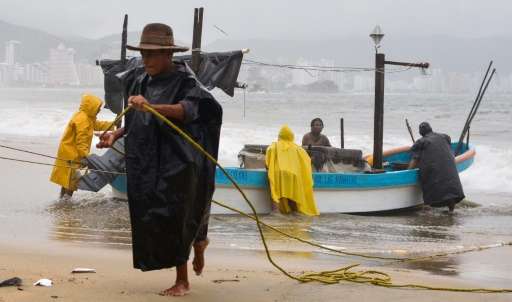 Fishermen take their boats out of the sea in anticipation of the arrival of Hurricane Max in Acapulco