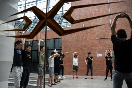 Gamers from various eSports teams take a break to perform some physical exercise during training for the League of Legends World