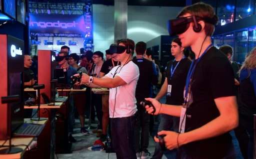 Gaming fans at an electronics show last month in Los Angeles test virtual reality gear of the sort used in a new 'Deadpool' game
