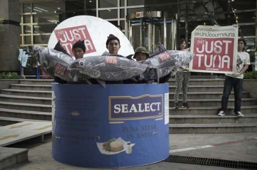 Greenpeace activists stand inside a large mock-up of a canned tuna in front of the Thai Union headquarters in Bangkok on October