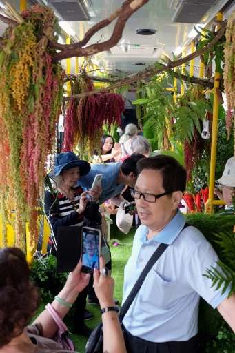 Journalists and passengers take photos of live vegetation inside the &quot;forest bus&quot; in Taipei