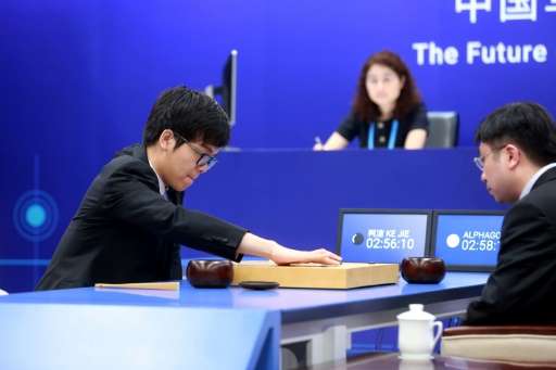 Nineteen-year-old Go player Ke Jie (L) makes a move during the first match against Google's artificial intelligence programme Al