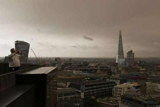 Office workers took time out to photograph the darkened sky over London, caused by warm air and dust swept up by storm Ophelia.