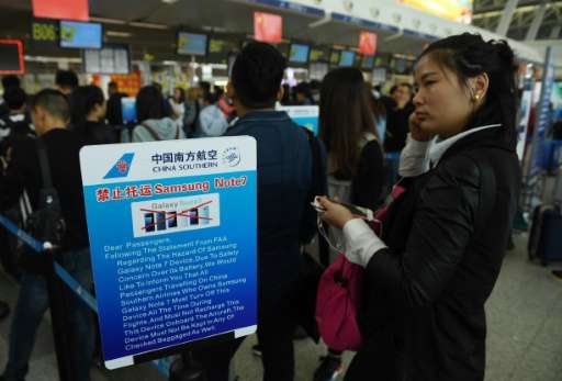Passengers line up beside a safety warning about the Samsung Galaxy Note 7 smartphone at China's Wuhan airport in this October 2