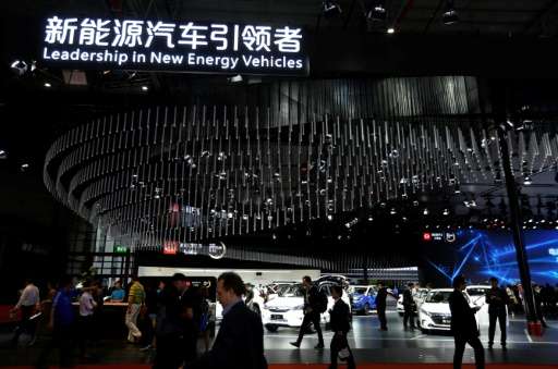 People visit the 'new-energy' vehicles area at the Shanghai Auto Show on April 19, 2017. With a quota threat looming, major manu