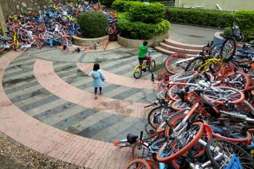 Rented bicycles from bike-sharing firms are stacked near the entrance of Xiashan park in Shenzhen, on January 16, 2017