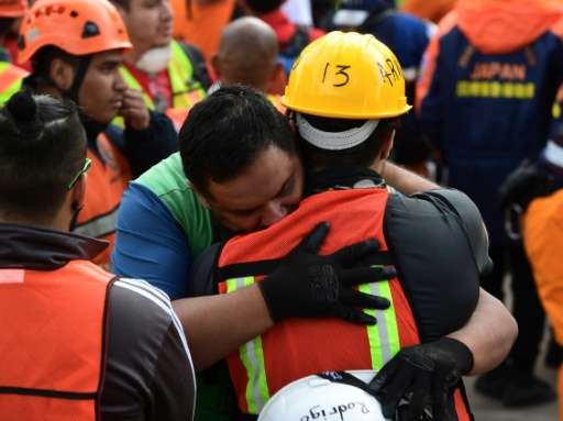 Rescue workers embrace after the seismic alert sounded in Mexico City