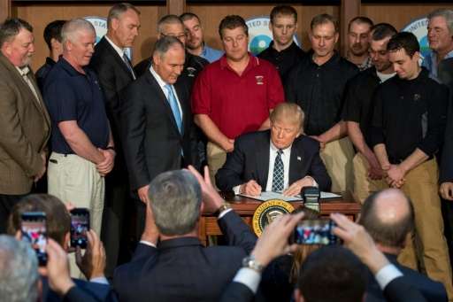 Surrounded by miners, President Donald Trump signs an order on Tuesday he said would end the &quot;war of coal&quot; by rolling 
