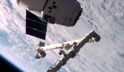 The Canadarm2 robotic arm is poised to grab the unmanned SpaceX Dragon cargo capsule in this NASA TV video grab from June 5, 201