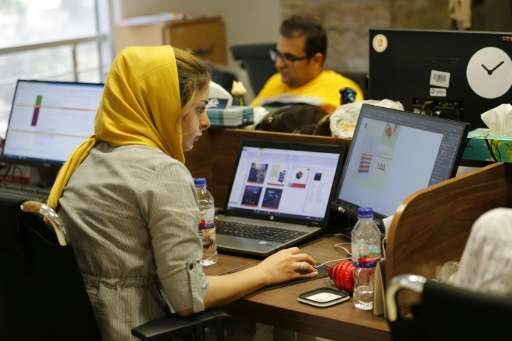 This file picture taken on July 09, 2017 shows employees at an e-commerce site's offices in the Iranian capital Tehran