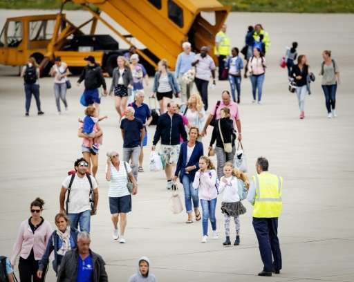 Tourists arriving with the first flight from Sint Maarten, walk on the tarmac at the Eindhoven Military Airbase