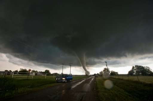 Vehicles stop on the side of a road as a tornado rips through a residential area in Oklahoma