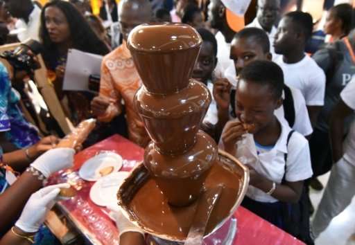 Visitors gather around a chocolate fountain at the opening of the fourth national cocoa and chocolate days in Abidjan