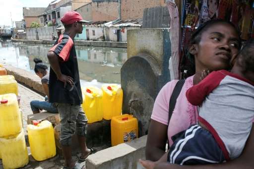 Water carrier LŽo (left) fills up a jerrycan in Antananarivo. Campaign group WATERAID says 65 percent of Madagascar's rural popu