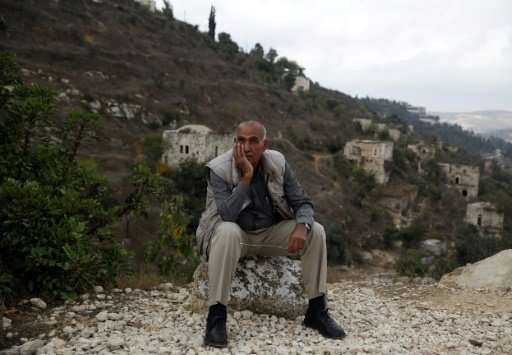 Yacoub Odeh, a 77-year-old Palestinian, sits by old houses in the ghost village of Lifta, whose Palestinian inhabitants fled dur