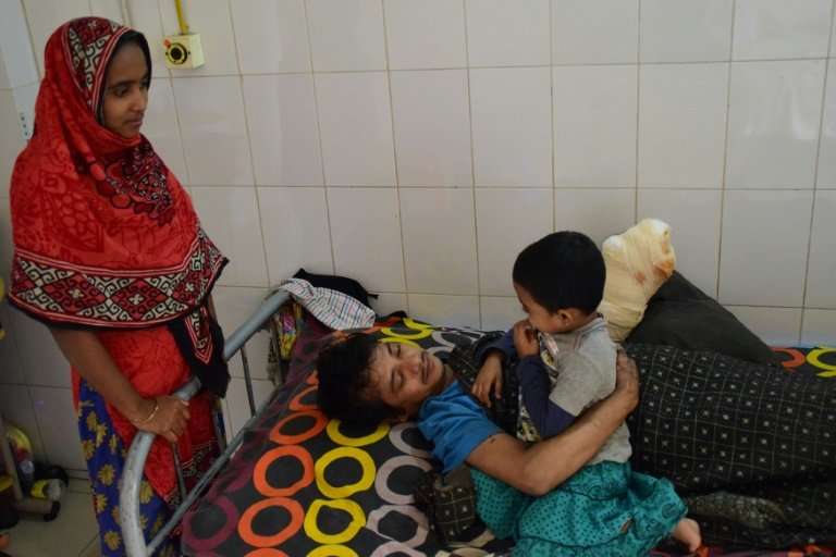 Abul Bajandar, with his family at a Dhaka hospital, worries about money and how he will pay for his daughter's education