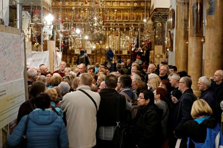 A group of tourists and pilgrims visit the Church of the Nativity, the place where Jesus is said to have been born, in the Bibli