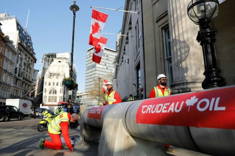 Demonstrators use a mock oil pipeline to block the entrance to the Canadian Embassy in central London as they protest against th