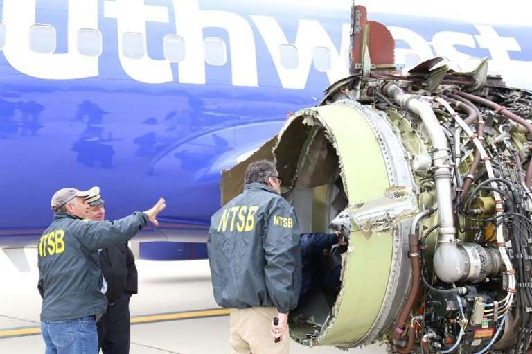 National Transportation Safety Board investigators examine damage to a Southwest Airlines plane that suffered catastrophic engin