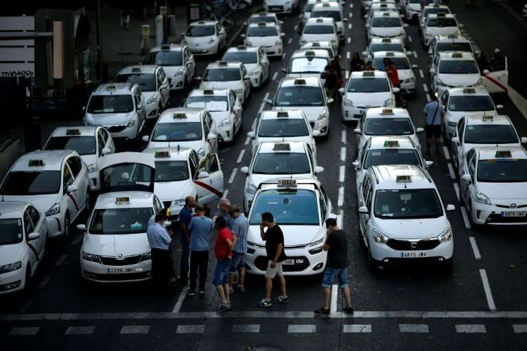Taxi drivers blocked a major avenue in Madrid on Tuesday as a strike against Uber-style ride hailing services was set to enter a
