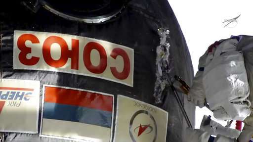 Spacewalking astronauts check site of capsule leak