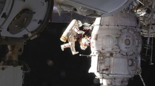 Spacewalking astronauts check site of capsule leak
