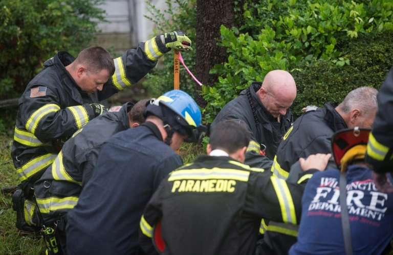 Firefighters pray during an operation to remove a tree that fell on a house as Hurricane Florence struck Wilmington, North Carol