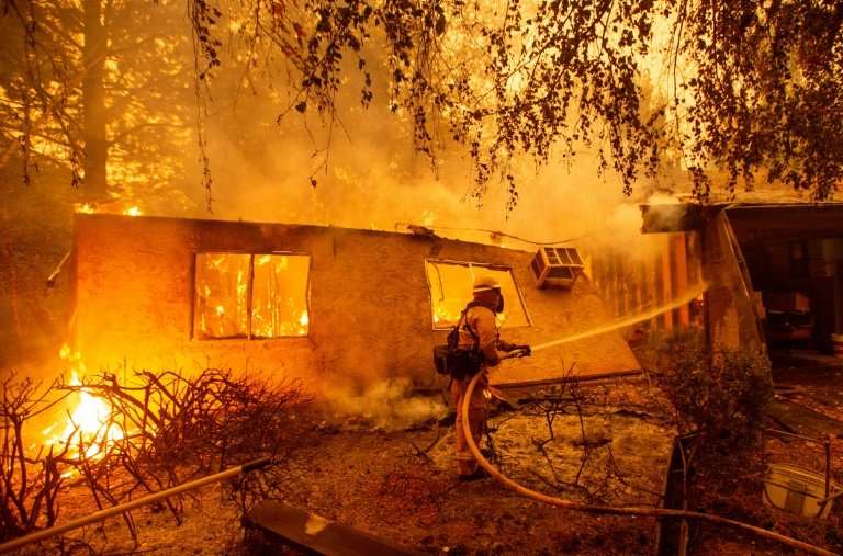Firefighters battle flames at a burning apartment complex in Paradise, California on November 9, 2018