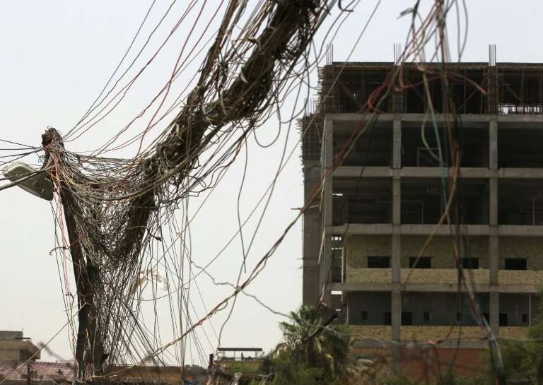 A picture taken on July 26, 2018, shows loose wires coming from a generator in Baghdad installed to supplement the poor public p