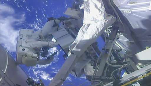 Spacewalking astronauts perform pump swap at space station