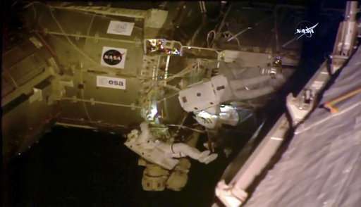 Spacewalking astronauts set up TV cameras for arriving ships