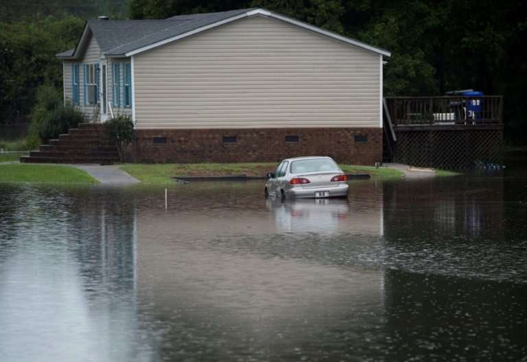 A car is partially submerged in floodwater near a house in Grifton, North Carolina