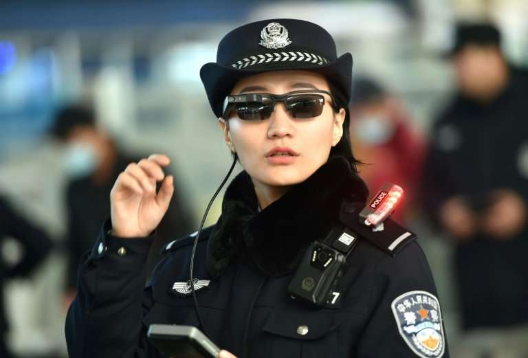 A Chinese police officer wears a pair of smartglasses with a facial recognition system at Zhengzhou East Railway Station in Zhen