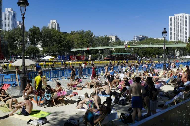 A crowded outdoor swimming pool on a canal in central Paris as people seek relief from near-record temperatures in a heatwave sw