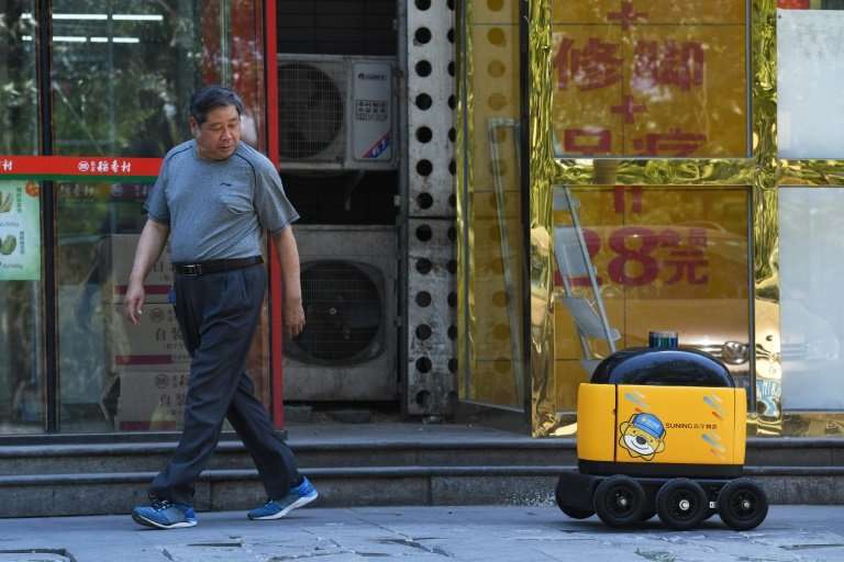 A delivery robot makes its way back to a supermarket after making a delivery during a demonstration in Beijing