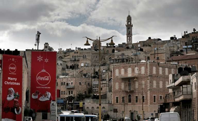 Advertising posters celebrating Christmas are seen on buildings in front of the Old City of the Biblical city of Bethlehem in th