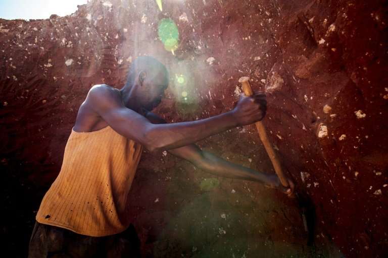 A man digs through some mine waste searching for left over cobalt near Kolwezi