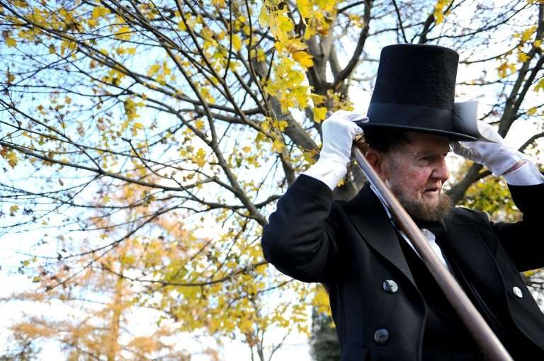 A man portraying US President Abraham Lincoln wears an example of Lincoln's trademark stovepipe hat