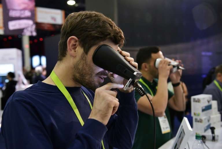 A man tries out the EyeQue Insight home visual acuity screener at the 2018 Consumer Electronics Show