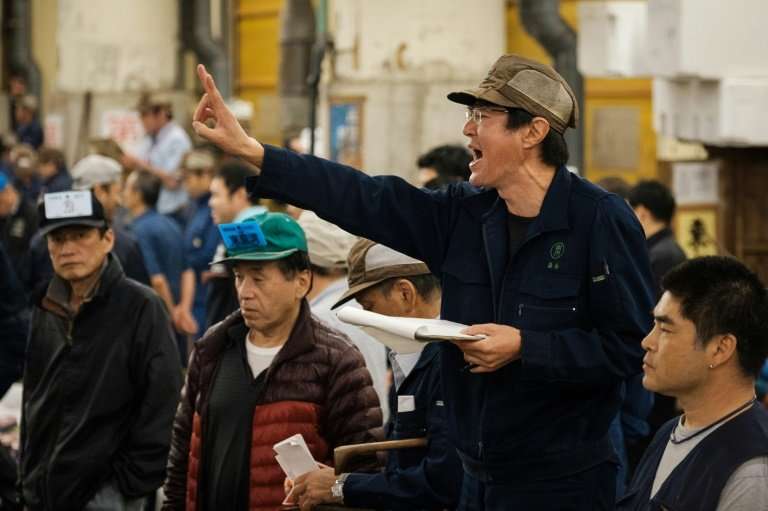 An auctioneer shouts out during the final tuna auction at Tokyo's Tsukiji fish market, which has closed its doors to relocate to