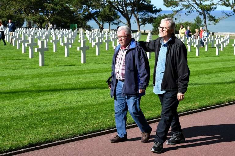 Andre Gantois and Allen Henderson, seen at the Normandy American Cemetery and Memorial, had the same GI father who landed near  