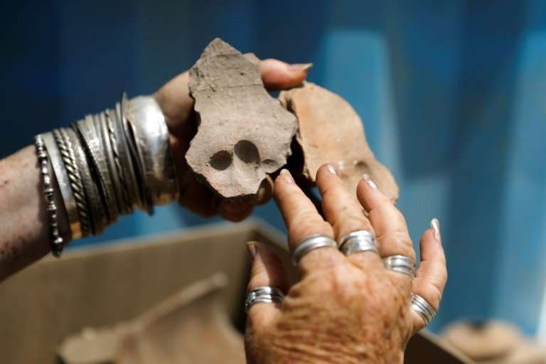 An Israel Antiquities Authority archaeologist shows shows pottery shreds with finger prints on them from the Byzantine time foun