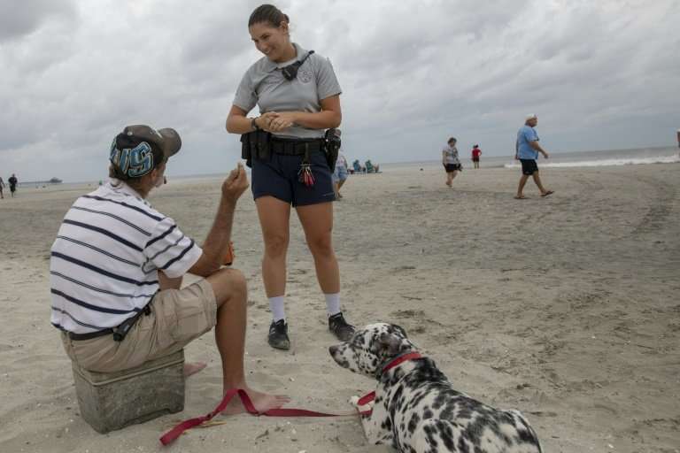 A North Myrtle Beach Police officer warns a beachgoer about the dangers of remaining on the beach as Hurricane Florence moves cl